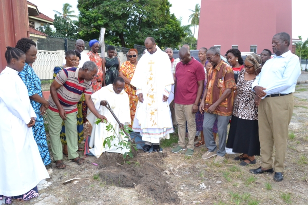 Dekano wa Dekania ya Mtakatifu Thomas More, Jimbo Kuu Katoliki la Dar es Salaam, Padri Romwald Mukandala (aliyeshika koleo), akipanda mti kuhamasisha utunzaji wa mazingira, ikiwa ni kuunga mkono kampeni ya Tumaini Media katika utunzaji mazingira. Askofu Mkuu wa Jimbo hilo, Mhashamu Jude Thaddaeus Ruwa’ichi alikabidhi miti hiyo kwa Madekano. Katikati mwenye kanzu ni Mlezi wa Seminari Kuu ya Segerea, Padri Siegfried Rusimbya Ntare, akishuhudia.